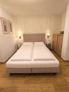 a large bed in a room with two lamps at Stein 35 with Kitzstainhorn view in Kaprun