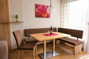 a dining room table with two chairs and a bottle of wine at Stein 35 with Kitzstainhorn view in Kaprun +6 photos