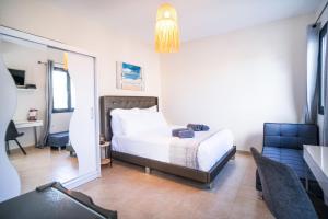 a bedroom with a bed and a desk and a chair at SeaSuites Artemida in Artemida