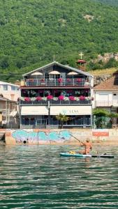 a man in a kayak in the water in front of a building at Villa Lena in Ohrid