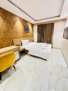a hotel room with two beds and a desk at Staylo Hotel Azora in New Delhi +4 photos