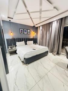 a bedroom with a large bed and a marble floor at Staylo Hotel Azora in New Delhi