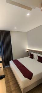 a bedroom with a large white bed in a room at AYMAN SYARIAH HOTEL in Surabaya
