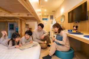 a family sitting on the floor in a hospital room at DreamFriend新浦安 in Tokyo