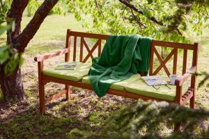 a wooden bench with a green blanket on it at Borbála Vendégház in Füzér