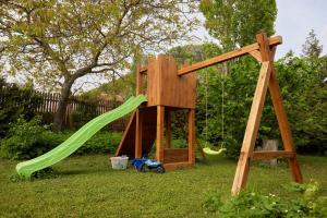 a wooden play set with a slide and a playground at Borbála Vendégház in Füzér