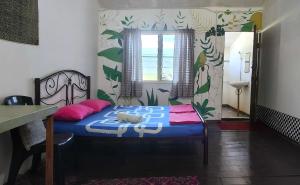 a bedroom with a blue bed with pink pillows at Mulu Village in Mulu