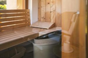 a bathroom with a toilet and a wooden bench at Lill' Hill estate & wellness - Lumina Chalet in Idrija +41 photos