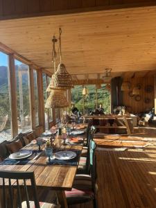 a dining room with a long wooden table with chairs at Alto Castillo Lodge in Villa Cerro Castillo