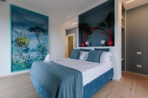 a bedroom with a bed with a painting on the wall at Dimore Tinè in Castellana Grotte