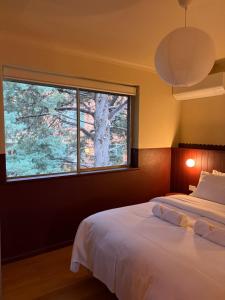 a bedroom with a bed and a large window at The Bron Apartment - newly renovated, designer stay in Yarralumla +9 photos