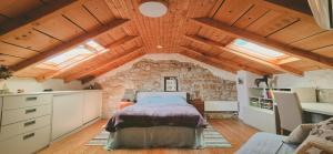 a bedroom with a bed and a stone wall at Istria Stone House in Marasi