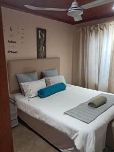 a bedroom with a large white bed with blue pillows at 101 Newlands West in Durban +38 photos