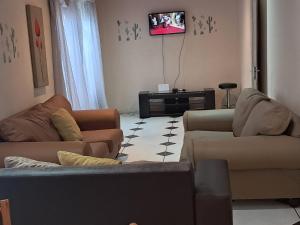 a living room with two couches and a flat screen tv at 101 Newlands West in Durban