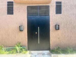 a black door in the side of a building at La MAISON SEONE STANDARD in Abidjan