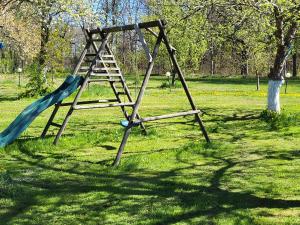 a swing set in a park with a slide at Gajowe Zacisze in Mirsk
