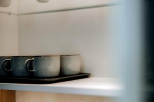 three pots sitting on a shelf in a kitchen at avocado domki in Kuśnie