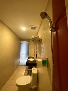a small bathroom with a toilet and a sink at Brothers Inn Babarsari in Yogyakarta +9 photos