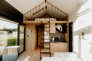 a room with a loft bed in a tiny house at avocado domki in Kuśnie