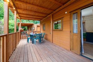 a wooden deck with a table and chairs on it at Camping Village Il Poggetto in Troghi