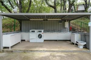a washing machine and a toilet in a garage at HolaCamp Aínsa in Aínsa
