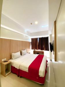 a bedroom with a large bed with a red and white blanket at Brothers Inn Babarsari in Yogyakarta