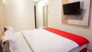 a bedroom with a bed and a flat screen tv at Brothers Inn Babarsari in Yogyakarta