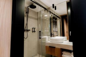 a bathroom with a glass shower and a sink at avocado domki in Kuśnie +33 photos