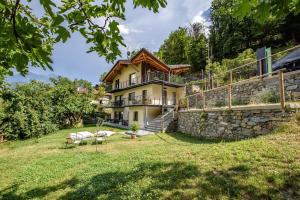 a house on a hill with a stone wall at "Lomà" - Aosta Valley EcoResort in Champdepraz