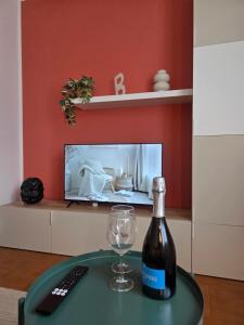 a bottle of wine and a glass on a table at La Tana - Borno Holiday in Borno +4 photos
