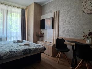 a bedroom with a bed and a desk with chairs at Apartments 17 - 23 AD Kamzík in Donovaly
