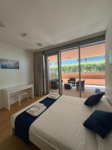 a bedroom with a large bed with a large window at Waterfront Porto Antico House in Genoa