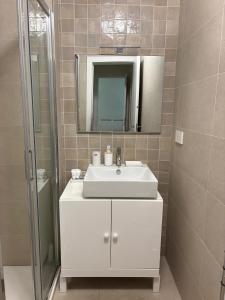 a bathroom with a white sink and a mirror at Waterfront Porto Antico House in Genoa +32 photos