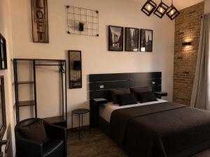 a bedroom with a black bed and a chair at LoFT in Bosa