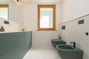 a bathroom with two green toilets and a sink at "Lomà" - Aosta Valley EcoResort in Champdepraz +100 photos