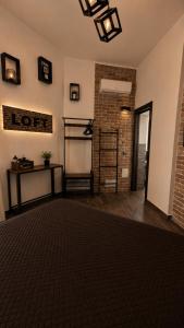 a living room with a table and a brick wall at LoFT in Bosa