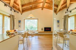 two views of a living room and dining room with wood ceilings at "Lomà" - Aosta Valley EcoResort in Champdepraz