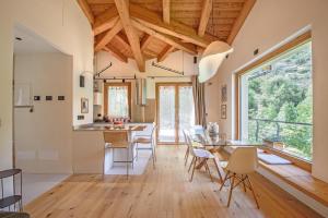a kitchen and dining room with a table and chairs at "Lomà" - Aosta Valley EcoResort in Champdepraz