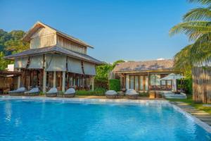 a resort with a swimming pool in front of a building at Rest Sea Resort Koh Kood in Ko Kood