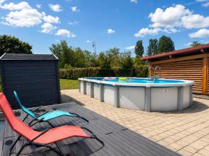 a patio with a hot tub and a table and chairs at Piscine et pétanque - Calme proche Belfort in Châlonvillars