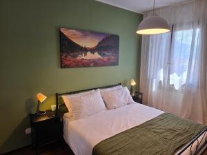 a bedroom with a bed and a painting on the wall at La Tana - Borno Holiday in Borno