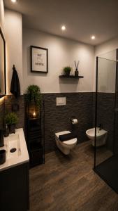 a bathroom with a toilet and a sink and a shower at LoFT in Bosa +26 photos