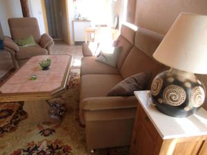 a living room with a couch and a lamp on a table at gemütliche Ferienwohnung in Kaifenheim in Kaifenheim
