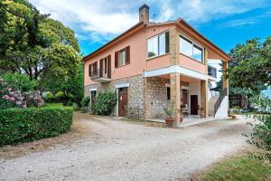 a large pink house with a gravel driveway at Casa Ortensia in Spoleto