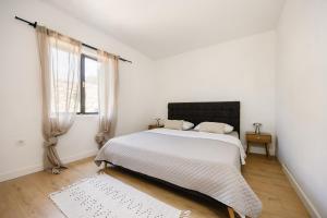 a white bedroom with a bed and a window at Seafront Villa in Kornati Private Terrace and Direct Beach Access in Kornati