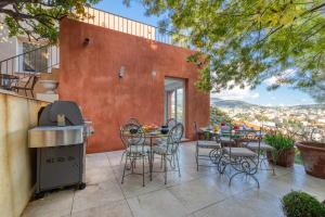a patio with a table and chairs and a grill at Villa sur les hauteurs de Nice, proche centre in Nice
