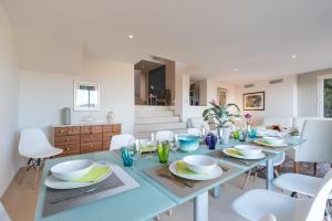 a dining room with a table and white chairs at Villa sur les hauteurs de Nice, proche centre in Nice +51 photos