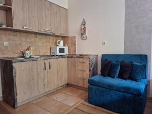 a kitchen with a blue couch and a microwave at Apartments 17 - 23 AD Kamzík in Donovaly