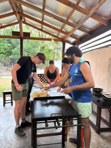 a group of people standing around a table preparing food at Surf and stay A- Bay in Arugam Bay