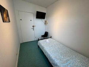 a small room with a bed and a chair at Le Lotus - 5 in Cherbourg en Cotentin